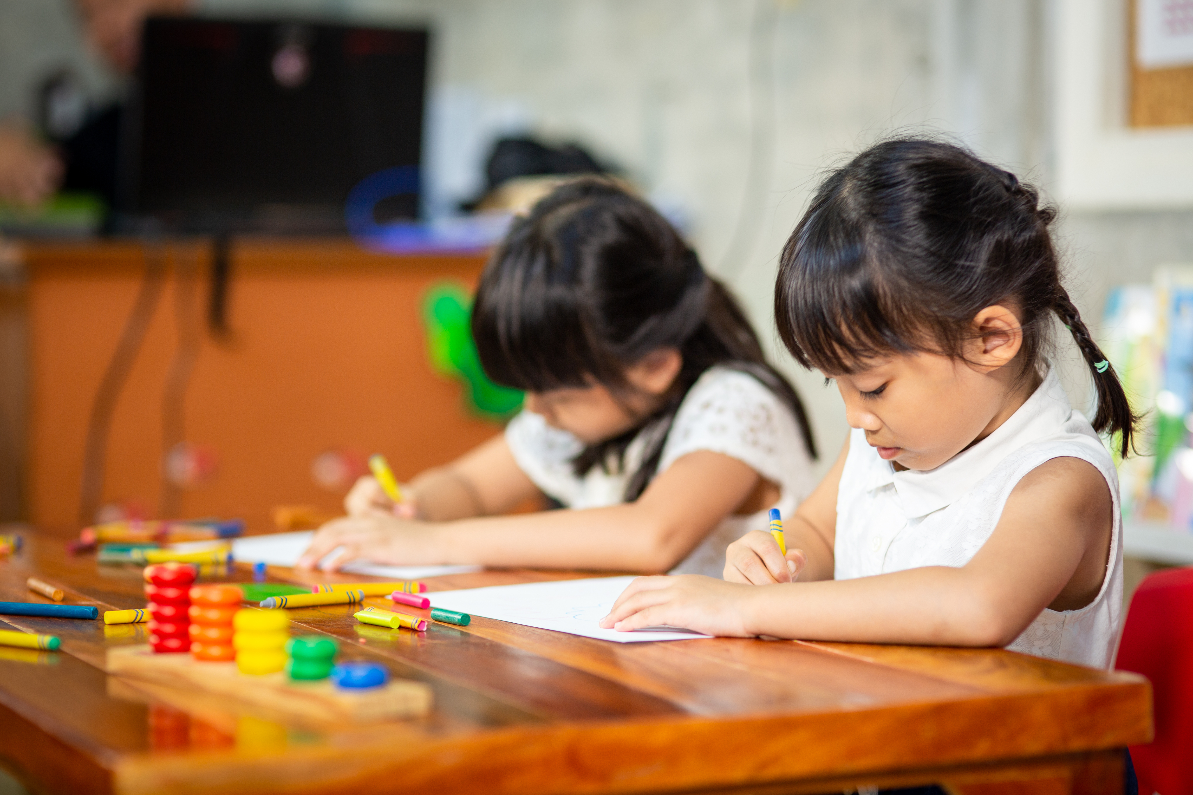 Children drawing at a desk